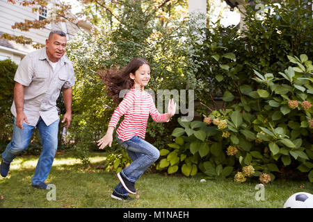 Nonno che giocano a calcio nel giardino con la nipote Foto Stock