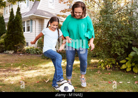 Nonna giocano a calcio nel giardino con la nipote Foto Stock