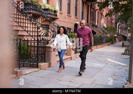 Coppia giovane camminando lungo la strada urbana a New York City Foto Stock