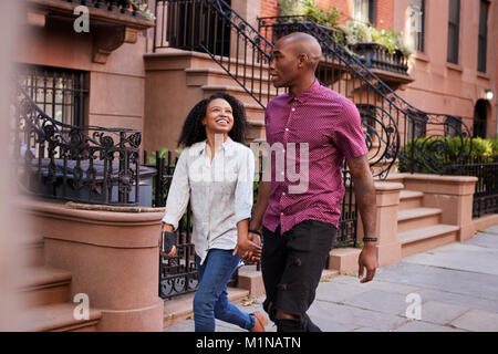 Coppia giovane camminando lungo la strada urbana a New York City Foto Stock