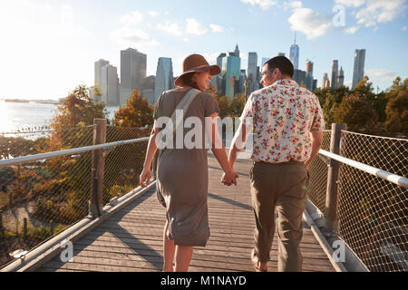 Matura in visita a New York con lo skyline di Manhattan in background Foto Stock