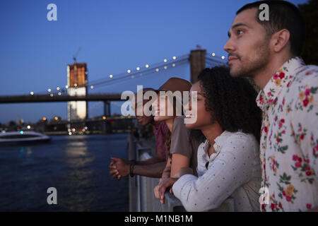Un gruppo di giovani amici in viaggio a Manhattan al crepuscolo Foto Stock