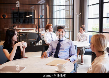 Colleghi di lavoro che parlano al loro ufficio cafe Foto Stock