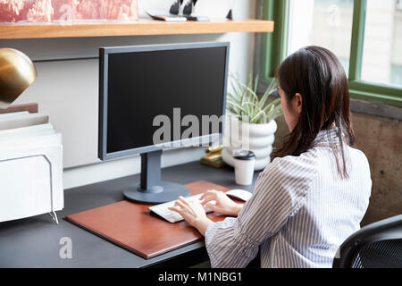 Giovane donna che lavorano a un computer in un ufficio, close up Foto Stock