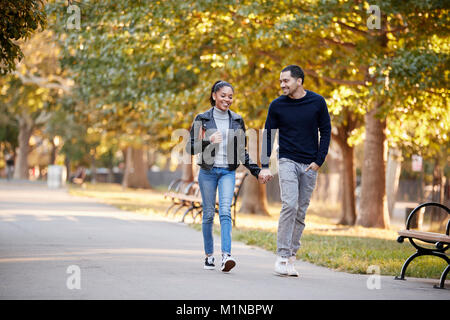 I giovani ispanici giovane camminando mano nella mano in Brooklyn Park Foto Stock