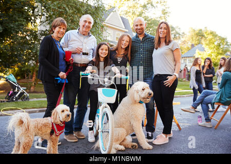 Vicini con cani sorridere alla telecamera a un blocco delle parti Foto Stock