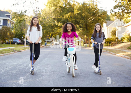 Tre pre-teen ragazze su scooter e moto cercando di fotocamera Foto Stock