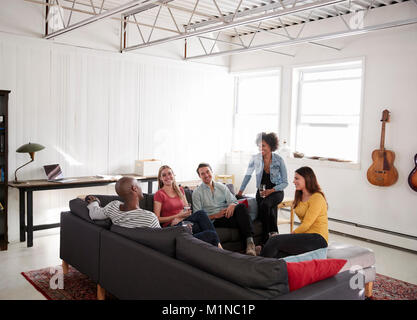 Cinque giovani amici di socializzare in una New York appartamento loft Foto Stock