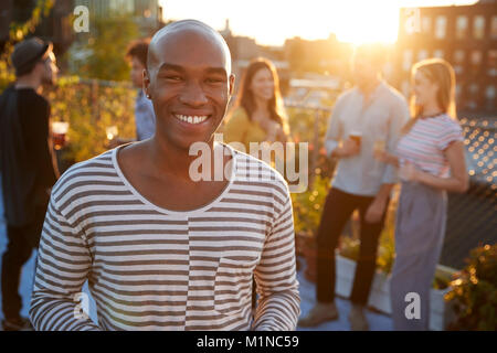 Giovane uomo nero a un tetto parte sorridente alla fotocamera Foto Stock