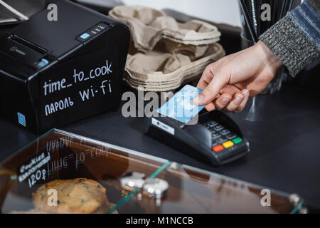Il cliente paga con credito contactless card in negozio. Foto Stock