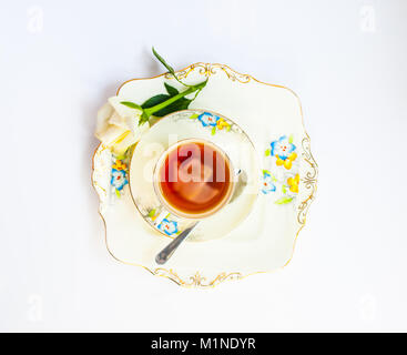 Flatlay con elegante set da tè con fiori di rose iat di riflessione la urface di liquido susseguono petali di rosa e fiori Foto Stock