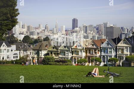 "Painted Ladies' è il nome di questo bel gruppo di case in stile vittoriano di fronte lo skyline di San Francisco Downtown. (16 febbraio 10^6) | utilizzo in tutto il mondo Foto Stock