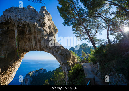 Luminoso vista panoramica dei mitici Faraglioni dal cliffside trail sull'isola Mediterranea di Capri, Italia Foto Stock