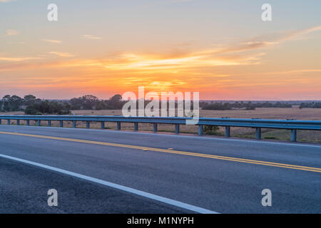 Una strada rurale attraverso Central Florida offre una fantastica vista del tramonto Foto Stock