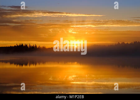 Con sunrise early morning mist over Kirchsee con Monastero Reutberg,Sachsenkam,Alta Baviera, Baviera, Germania Foto Stock