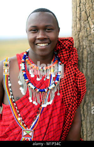 Ritratto di un uomo Masai indossando variopinti abiti tradizionali, il Masai Mara Game Reserve, Kenya, Africa orientale, Africa Foto Stock