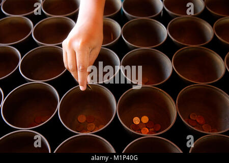 Bambino offrendo monete in Wat Suandok, Chiang Mai, Thailandia, Sud-est asiatico, in Asia Foto Stock