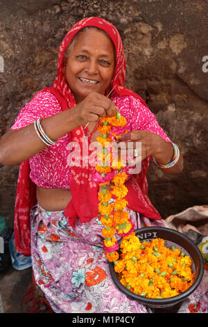 Donna indiana rendendo ghirlande in Ajmer, Rajasthan, India, Asia Foto Stock