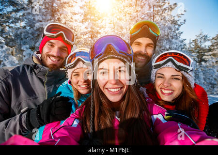 Happy amici prendendo foto con il telefono cellulare vacanza invernale Foto Stock