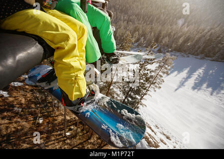 Close up di sciatori le gambe di ski-lift con lo snowboard e sci, concept Foto Stock