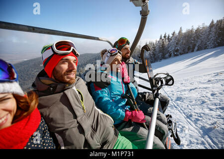 Gli sciatori che va al terreno di sci con impianti di risalita in inverno una giornata di sole Foto Stock