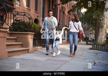 Famiglia facendo una passeggiata lungo la strada Foto Stock