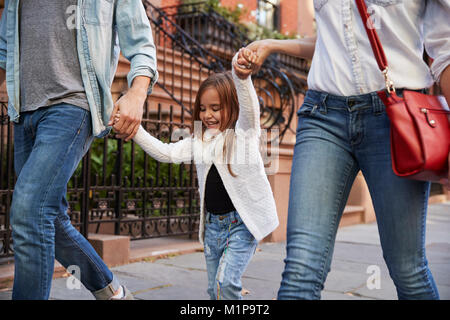 Famiglia facendo una passeggiata lungo la strada Foto Stock