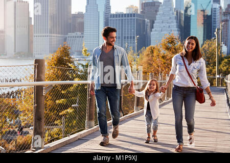 Famiglia giovane con la figlia facendo una passeggiata sulla passerella Foto Stock