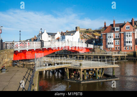 Whitby ponte girevole vivacemente dipinte di rosso visto dal lato ovest del fiume Esk con strutture di guida per evitare danni dal passaggio di barche Foto Stock