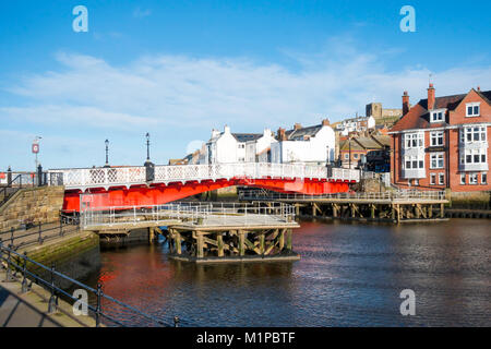 Whitby ponte girevole vivacemente dipinte di rosso visto dal lato ovest del fiume Esk con strutture di guida per evitare danni dal passaggio di barche Foto Stock