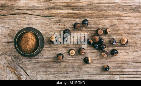 Il guaranà fagioli e polvere di legno su sfondo, vista dall'alto Foto Stock