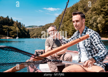 Padre e figlio durante la pesca sul lago Foto Stock