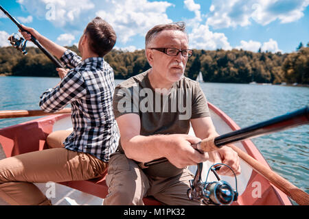 Gli uomini in attesa di pesce e mordere Foto Stock