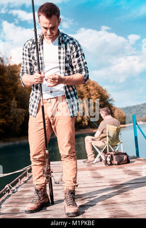 Nipote di adulti la pesca con il nonno sul molo Foto Stock