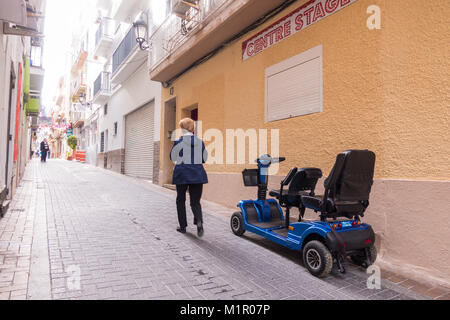 Turistici come utilizzare mobilità noleggiato scooter in strada di Benidorm, Spagna Foto Stock