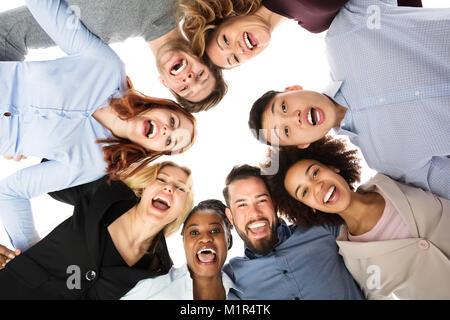 Basso angolo vista di Felice multirazziale studenti del college formando Huddle Foto Stock