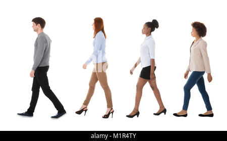 Maschio e femmina di studenti del college a camminare in fila contro sfondo bianco Foto Stock