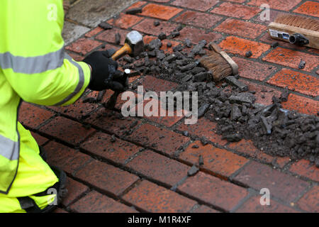 Gli uomini a fare street riparazioni in North Street, Chichester, West Sussex, Regno Unito. Foto Stock