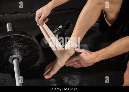 Close-up di una persona che indossa la gamba benda In Palestra Foto Stock