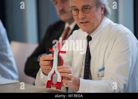 Hans-Henning Eckstein, direttore della chirurgia vascolare clinica, mostra un modello di un malato arteria addominale con una protesi come un esempio di una procedura chirurgica durante la cerimonia inaugurale conferenza stampa presso la clinica a destra del fiume Isar a Monaco di Baviera, 1 febbraio 2018. Neurochirurgia, chirurghi vascolari e urologi stanno andando avere otto nuove sale operatorie per lavorare a. Foto: Lino Mirgeler/dpa Foto Stock