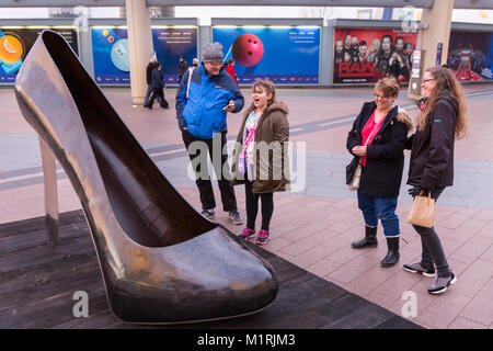 Penisola di Greenwich, Londra, UK, 1 feb 2018. Le persone interagiscono con le opere d'arte. Pubblica inaugurale il posizionamento di un trio di sculture, Bra, Stiletto Heel e Corsetto da acclamato artista Kalliopi Lemos, chi è presente per l'anteprima del Peninsula Square sulla penisola di Greenwich. La celebre opera forma parte di una serie in corso "strumenti del endearment', le tre opere sono esposte insieme per la prima volta dal 1 febbraio, sulla strada principale per l'O2, ed è presentata dalla galleria ora. Credito: Imageplotter News e sport/Alamy Live News Foto Stock