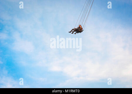 Volando in alto, osserva una coppia che si gode un giro sulla seggiovia Prater Turm (torre) nel famoso parco divertimenti Prater, Vienna, Austria. Foto Stock