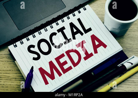 Social Media. Il concetto di business per la comunità di social media scritto sul libro dei notebook su sfondo di legno in ufficio con il caffè per laptop Foto Stock