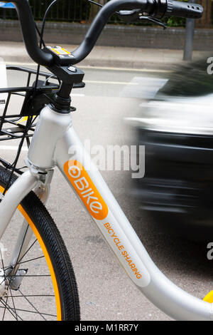 Londra, Inghilterra. Il traffico che passa un Obike inutilizzati in Fulham seguendo il servizio di lancio travagliato a Londra. Foto Stock