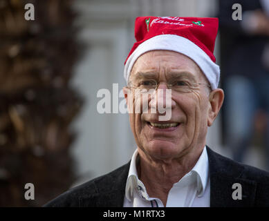 Close-up in posa con un berretto di Babbo Natale nel giardino della casa Foto Stock