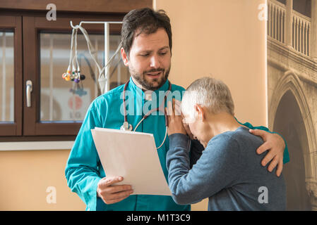 Medico confortante il suo paziente e che mostra il supporto Foto Stock