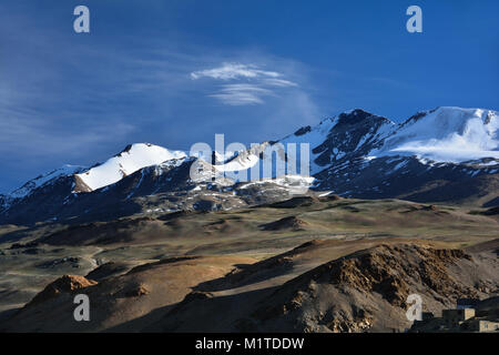 Montagne, colline con mackgie superficie verde, sulla sommità del ghiaccio eterno e nevai sotto il cielo blu con nuvola bianca. Foto Stock