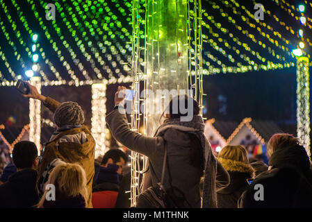 Mercatino di Natale e concerto in centro citta'. Per coloro che godono di evento, scatto di foto e registrazione di video. Splendide decorazioni e luci incandescenti. Foto Stock