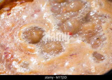 Ebollizione, calda zuppa di gulasch con carne, paprica, patate, cipolle, carote è un piatto tradizionale della cucina ungherese. Spezzatino di carne viene preparato in tegame di coccio Foto Stock