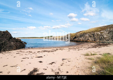 Isola di Llanddwyn piccola baia con spiaggia e scogliere su un soleggiato nella tarda estate del giorno, Anglesey, Galles Foto Stock